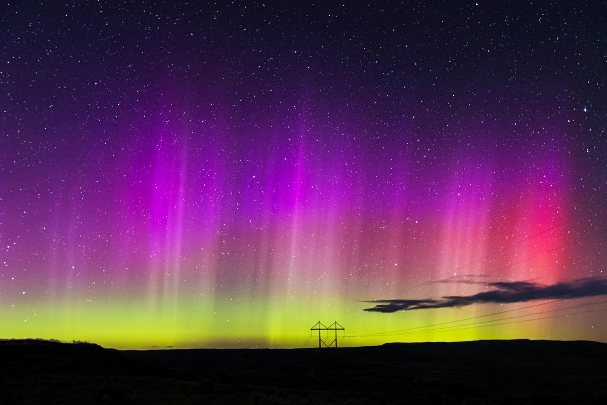 Light beams from the Aurora Borealis ( Northern Lights ) dance across the night sky on May 11, 2024